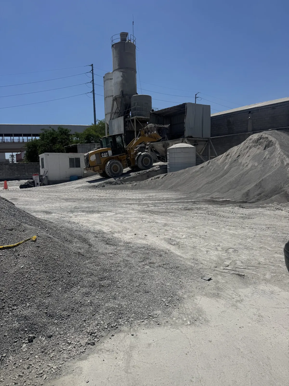 Cargador frontal frente a los silos de la planta