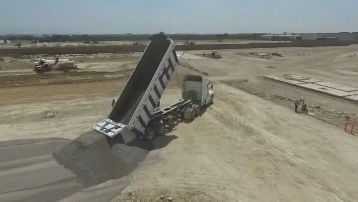 Entrega de material en obra con camión de volteo